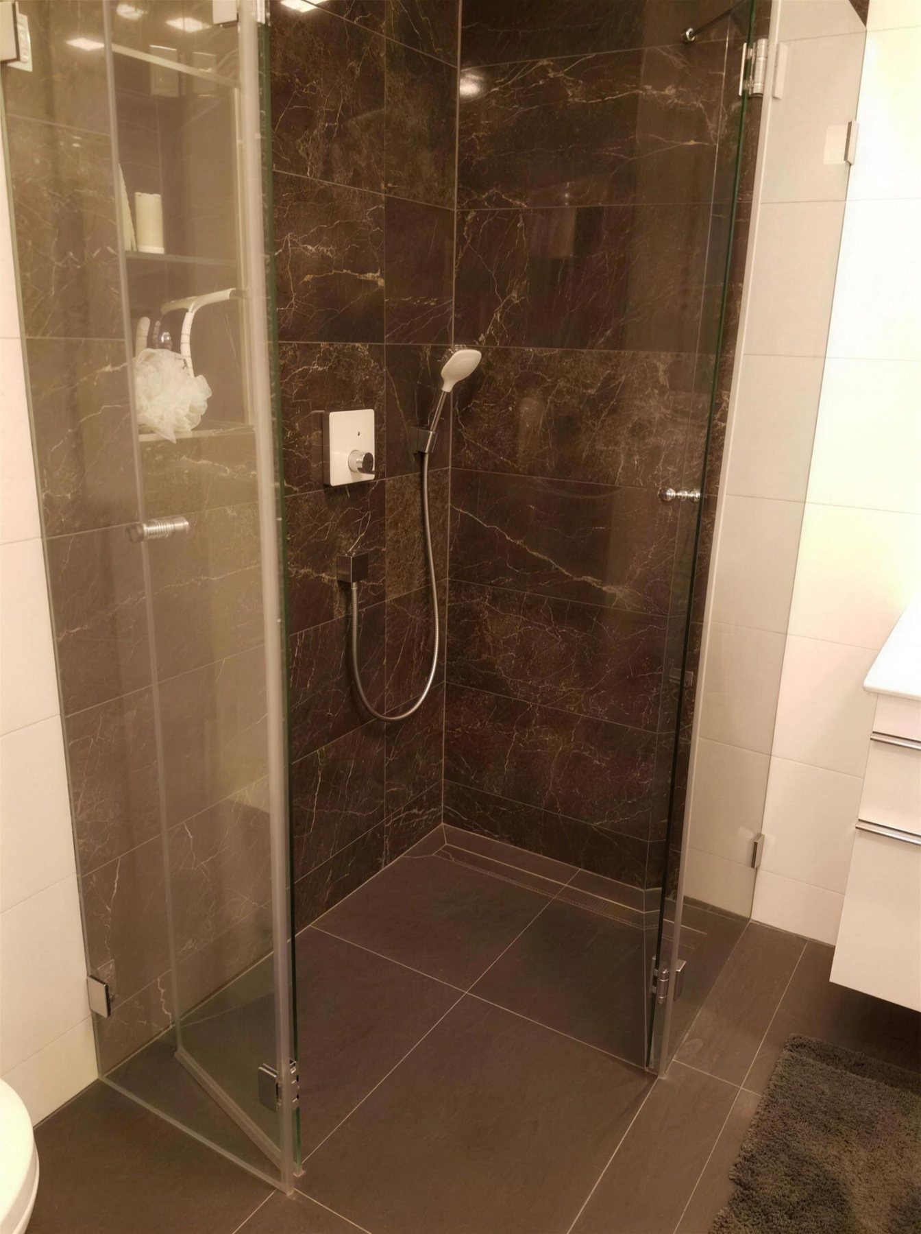 Dusche mit dunklen Marmorfliesen und Glasabtrennung, ein Projekt von Fliesen Vorrat